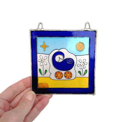 LeKoky Hand-painted blue pram design suncatcher for baby boys, with a high-quality, clear glass finish. Measures approximately 10 cm x 10 cm and weighs approximately 110g. Product held for scale demonstration.