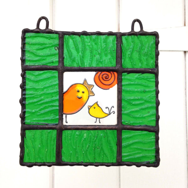 LeKoky Hand-painted glass suncatcher featuring a mama bird and her baby with a spiral sun in the background, framed with high-quality structured green coloured glass and black finish soldering touch.
